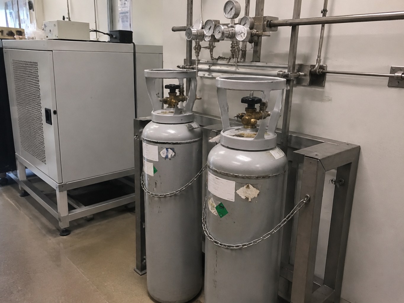 Compact deuterium cylinders chained to a high-purity laboratory gas manifold.