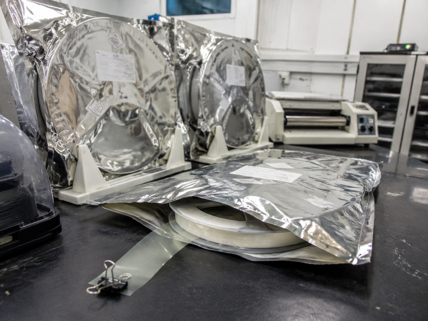 Moisture-barrier pouches holding die attach film rolls on a semiconductor workbench