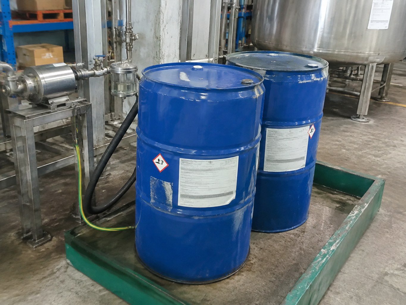 Blue epichlorohydrin drums in a bunded epoxy resin processing area.