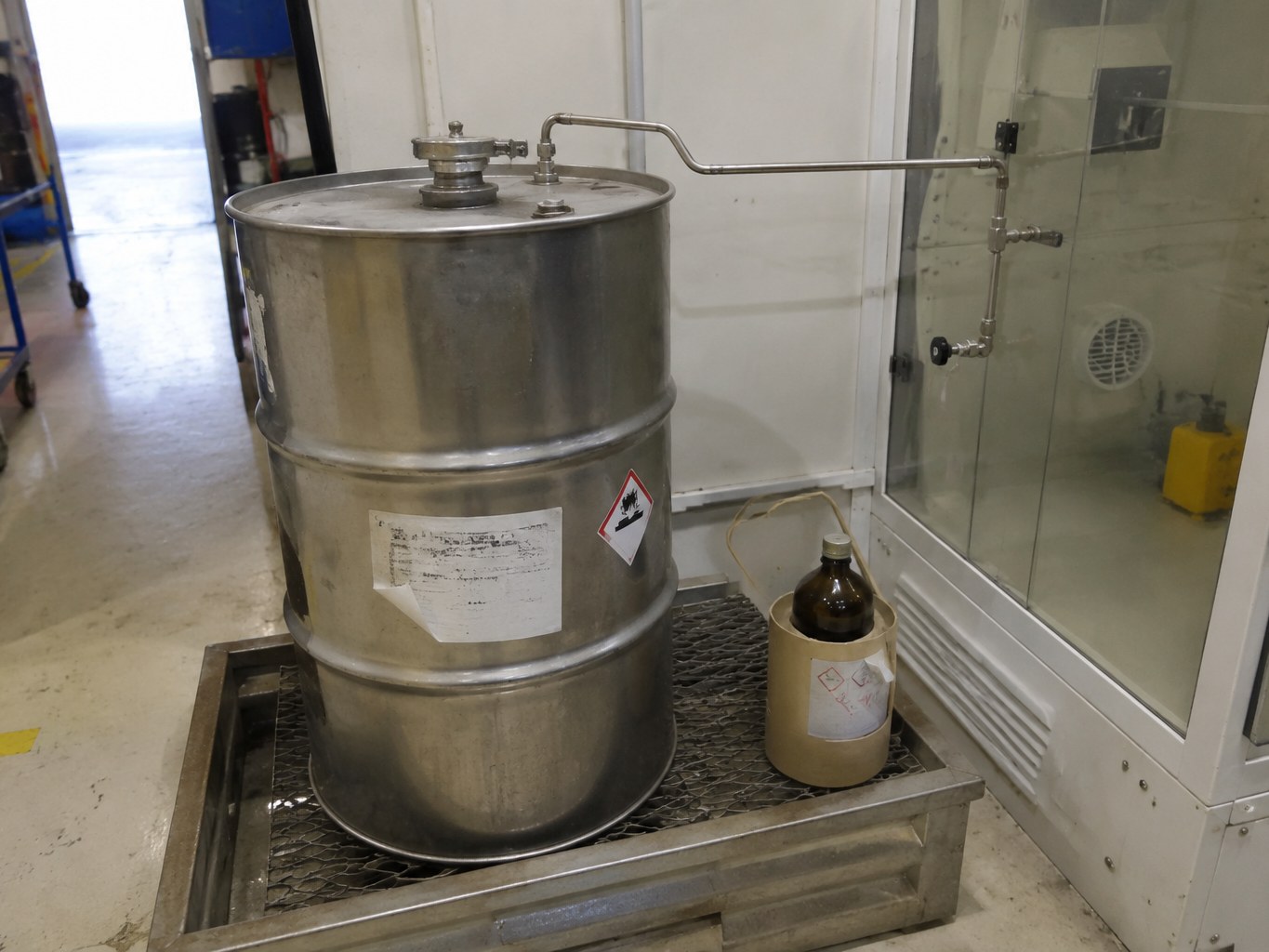 Sealed stainless drum of hexamethyldisilazane with a sample bottle in a ventilated store.