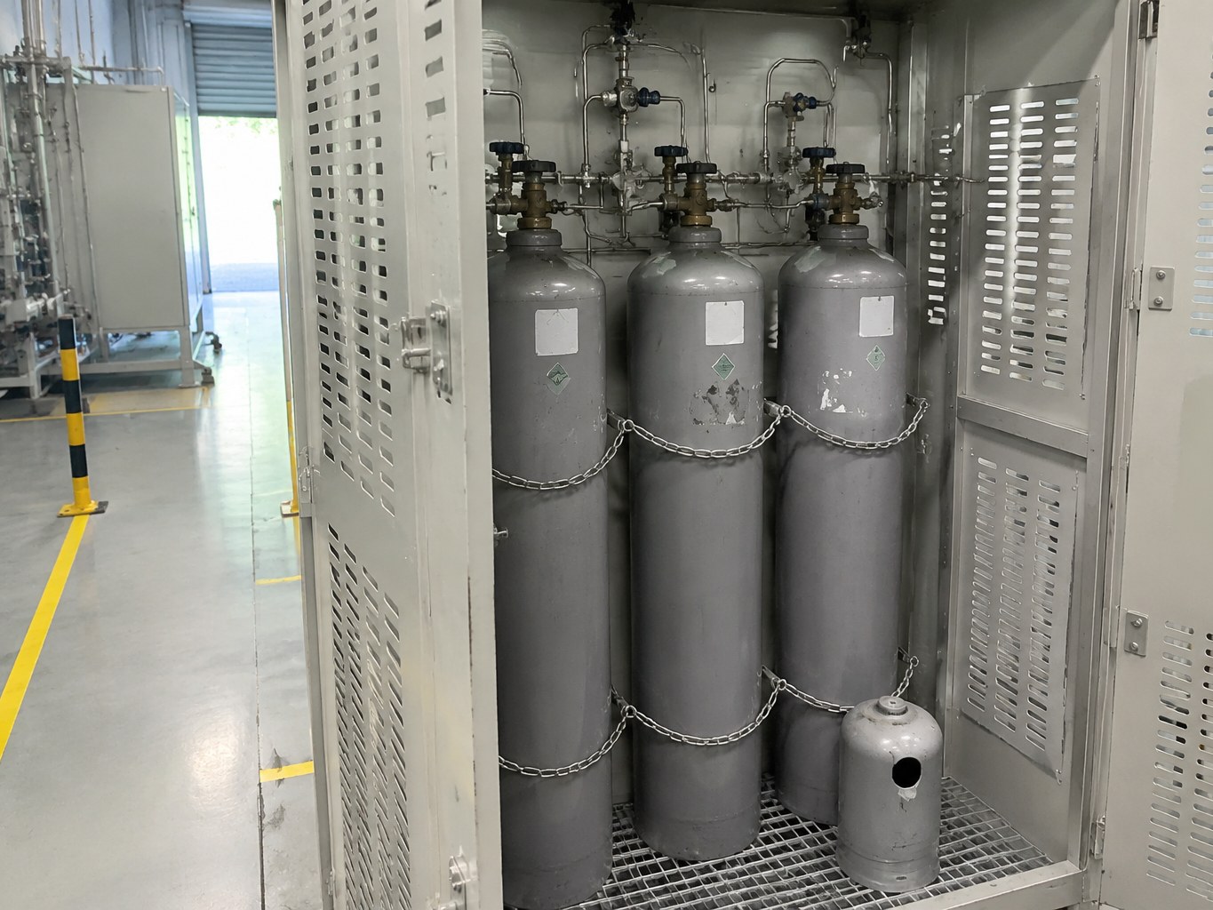Secured nitrogen trifluoride cylinders connected to a clean semiconductor gas manifold