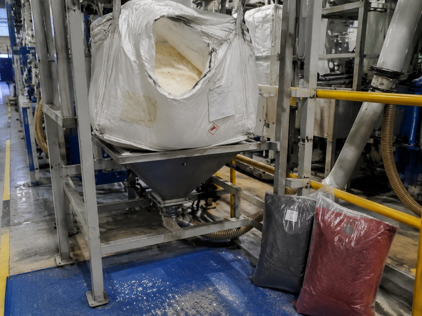 Bulk bag of natural nylon 6 pellets feeding a plastics compounding hopper