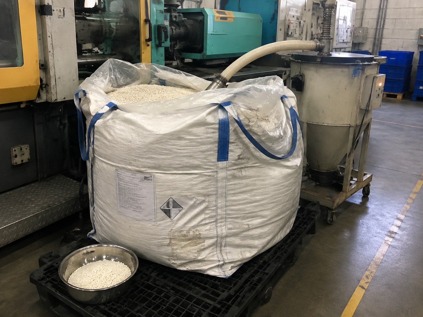 Bulk sack of natural nylon 66 pellets feeding an injection-moulding hopper.