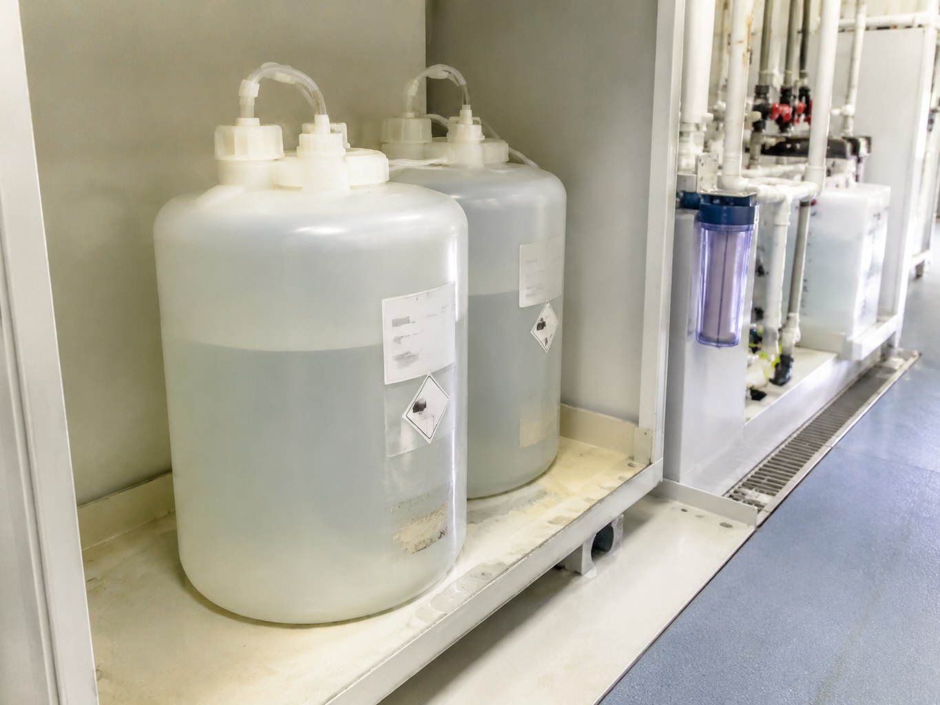Translucent carboys of photoresist developer connected to semiconductor wet-process filtration lines