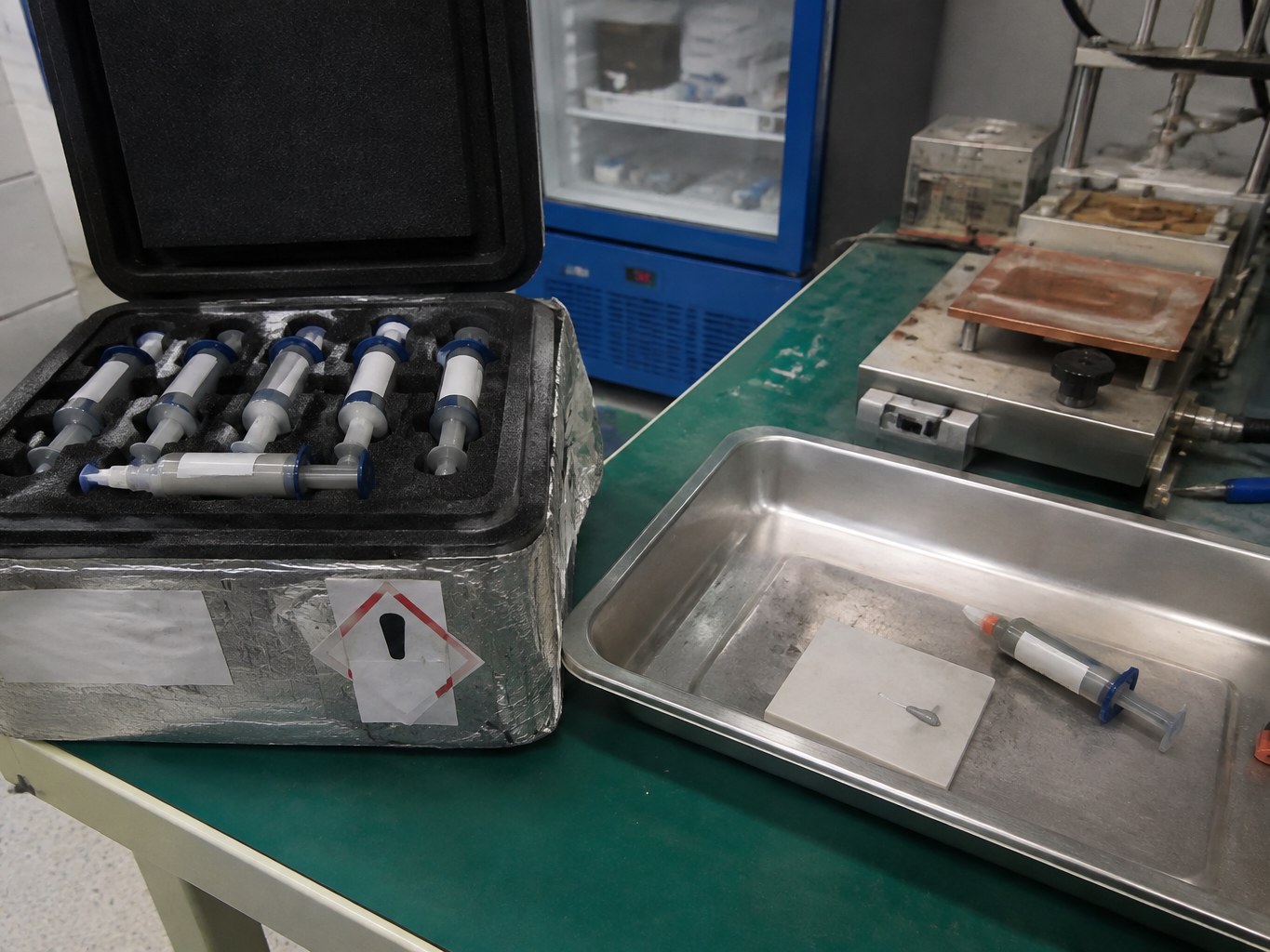 Insulated case of silver sintering paste syringes on a power-electronics assembly bench