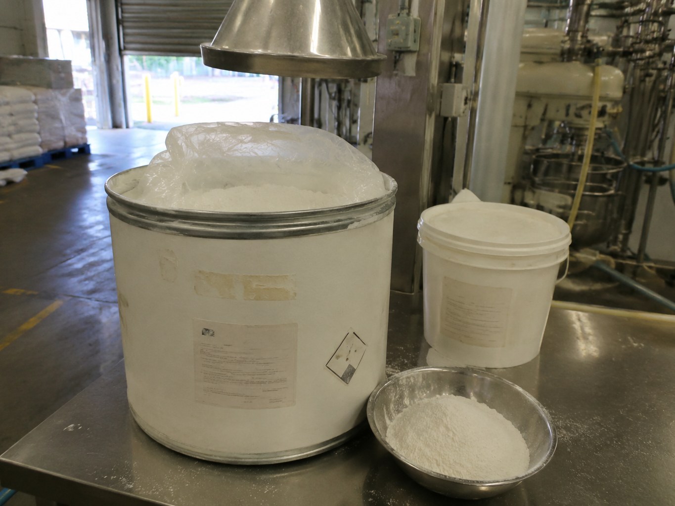 Open fibre drum of white sodium lauroyl glutamate powder on a formulation bench