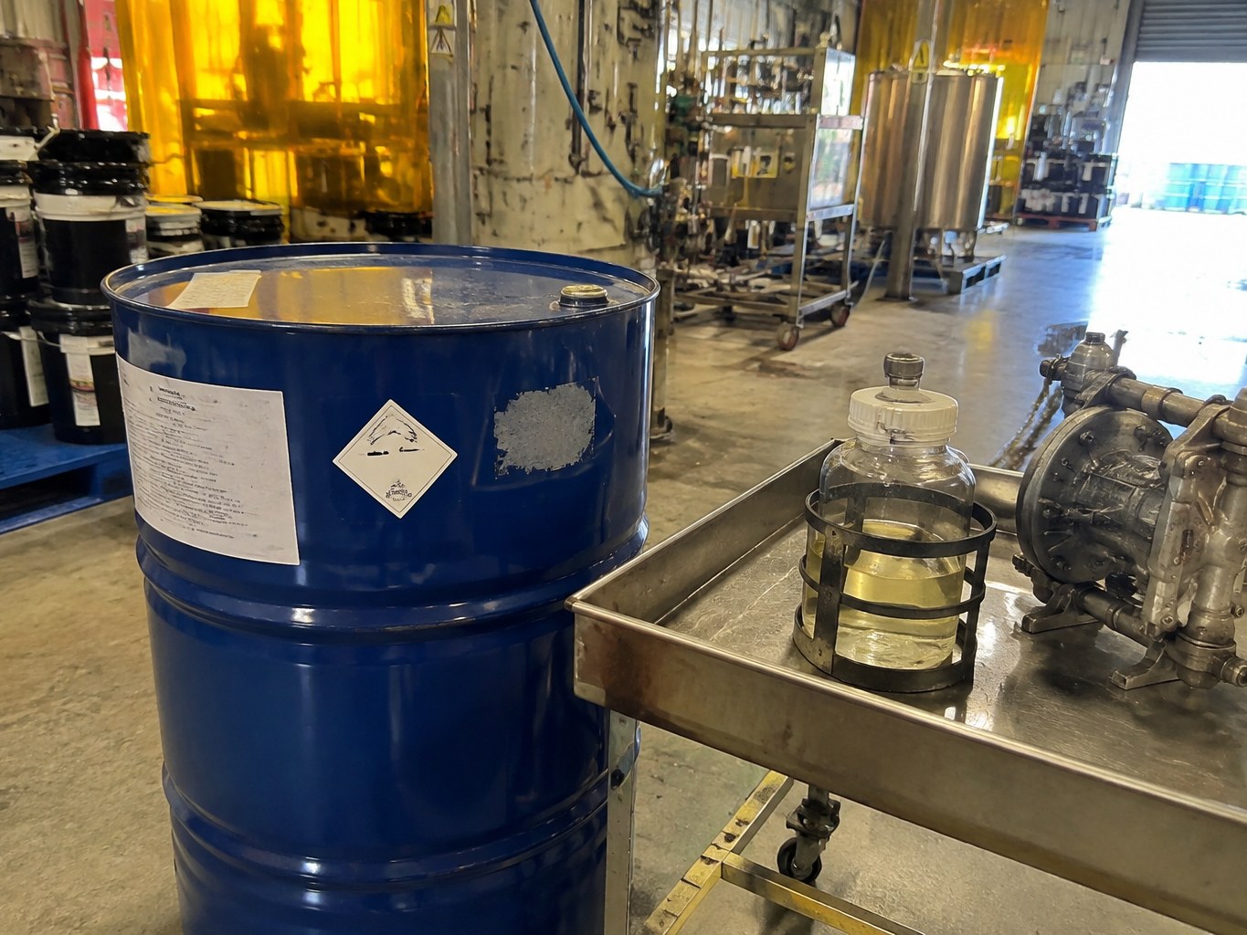 Blue drum and clear tetrahydrofurfuryl acrylate sample in a UV-resin production area.