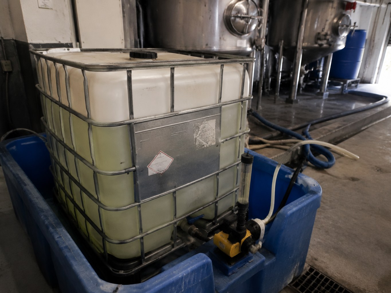 Clear thiodiglycol in an IBC beside textile chemical dosing equipment